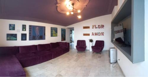 een woonkamer met een bank en een flatscreen-tv bij Hostal Casa Violeta in Tepic