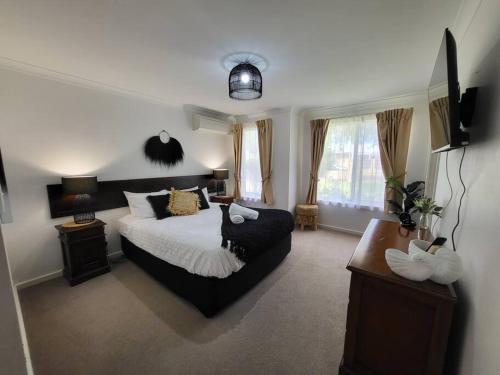 a bedroom with a bed and a couch at Villa Cinta @Cape View Resort in Broadwater