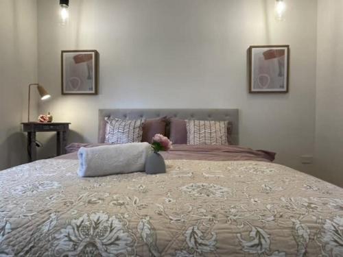 a bedroom with a large bed with two pictures on the wall at Evies Belmont Cottage in Geelong