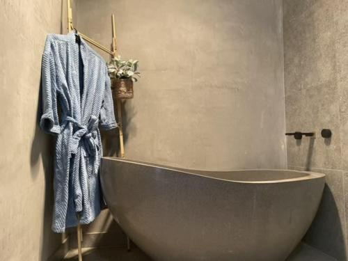 a bath tub in a bathroom with a blue towel at Evies Belmont Cottage in Geelong