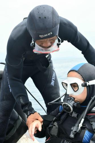 a man in a wet suit on a boat in the water at Villa Mangrove Pulau Pahawang in Lampung
