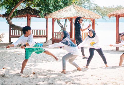 a group of people playing volleyball on the beach at Villa Mangrove Pulau Pahawang in Lampung