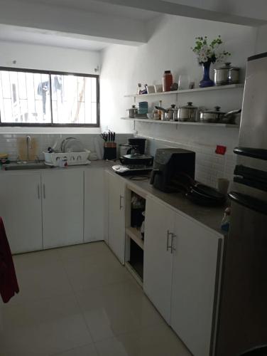 a kitchen with white cabinets and a counter top at Atardeceres Puntarenas in Puntarenas