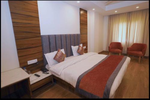 pokój hotelowy z łóżkiem i 2 krzesłami w obiekcie Hotel Aaria w mieście Mussoorie