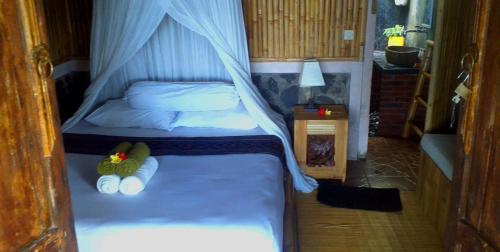 a small bedroom with a bed with a canopy at Lafyu Bali in Singaraja