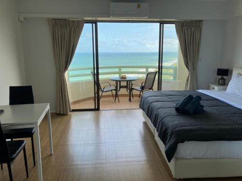 1 dormitorio con cama y vistas al océano en Vip condo chain by Linda en Ban Phe