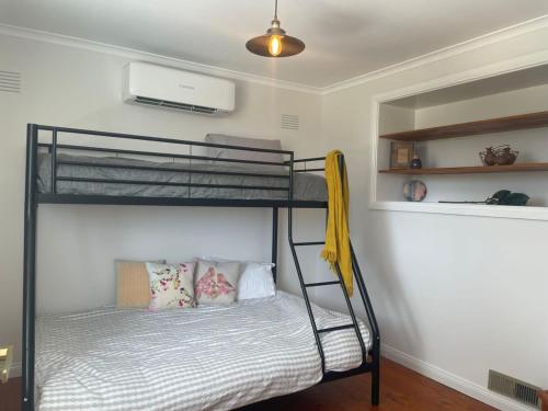 a bedroom with two bunk beds and a fan at Evies White House Oasis I Pool & Close to Airport in Melbourne