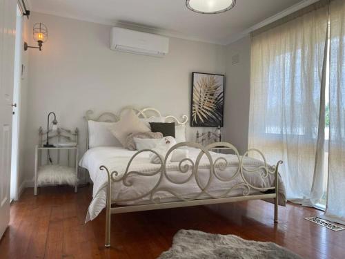 a bedroom with a white bed with white pillows at Evies White House Oasis I Pool & Close to Airport in Melbourne