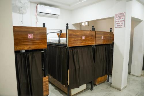 - un lit dans une chambre à côté d'un mur avec des rideaux dans l'établissement Hotel Aaram Kalupur, à Ahmedabad