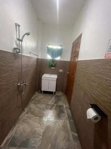 ein Bad mit einer Dusche, einem Waschbecken und einem WC in der Unterkunft Seaview Mansion Apartment 1 in Dalaguete