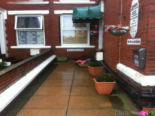 a brick building with two windows and potted plants at Deneside Guest House in Blackpool
