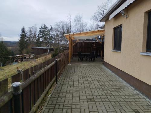 a patio of a house with a wooden fence at Müller's Ferienbungalow "Zur Göltzschtalbrücke" in Greiz