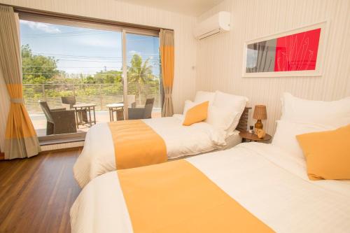 Ένα ή περισσότερα κρεβάτια σε δωμάτιο στο ハワイアンな空間が心身ともに癒してくれる　恩納村真栄田~K’s Casa~