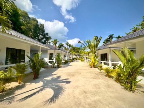 a pathway between two buildings with palm trees at Moorea Boutique Resort Samui in Koh Samui 