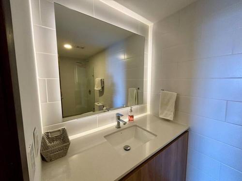 een badkamer met een wastafel en een grote spiegel bij Tropical Apartment in the city in Guatemala