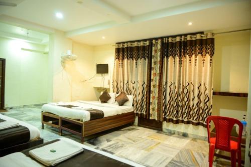 a bedroom with a bed and a table and a chair at Hotel Sachidanand in Shirdi