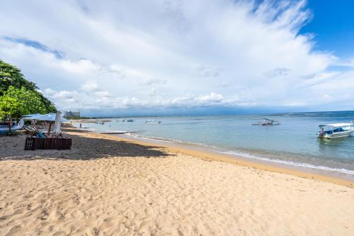 una playa de arena con barcos en el agua en Kejora Beachfront Villas, en Sanur