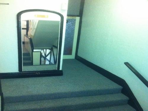 a stairway with a mirror and a stair case at Deneside Guest House in Blackpool