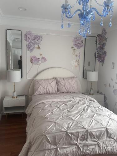 a bedroom with a bed with two mirrors and a chandelier at EdisonHollywood in Edison