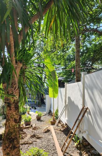 a chair sitting under a palm tree next to a fence at Easy Life Koh Chang in Ko Chang