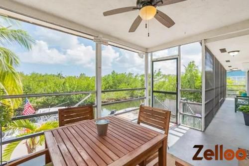 a large screened in porch with a wooden table and chairs at Experience Coastal Living at its Best Florida Keys in Summerland Key