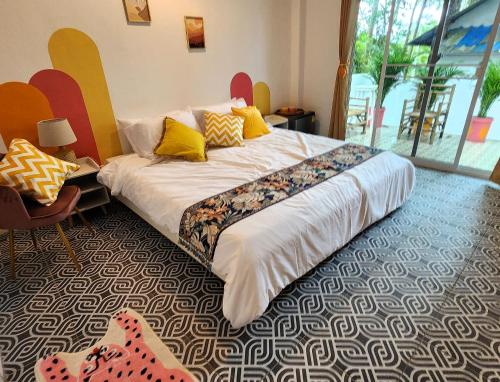 um quarto com uma cama grande e almofadas amarelas em Easy Life Koh Chang em Ko Chang