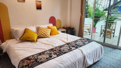 a bedroom with a bed with yellow pillows on it at Easy Life Koh Chang in Ko Chang