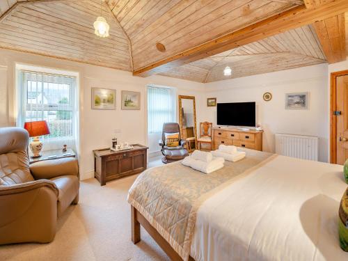 a large bedroom with a large bed and a television at Steppe Haugh in Hawes