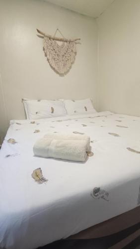 a bedroom with a white bed with white sheets at Sinurambi 2 in Kundasang