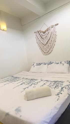 a white bed with a chandelier hanging on the wall at Sinurambi 2 in Kundasang