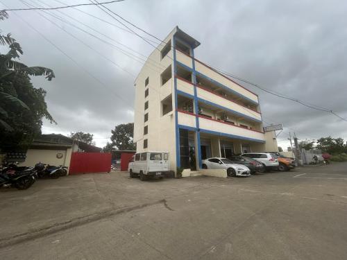 a tall building with cars parked in a parking lot at Caishen Apartelle 301 in Silang