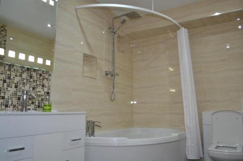 a bathroom with a tub and a shower and a toilet at Heathrow Travellers Hub in Hounslow