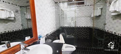 a bathroom with a toilet and a sink and a shower at Friendly Homestay in Kon Tum