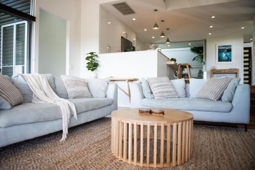 エアリービーチにあるBellevue Holiday Home - Airlie Beachのソファ2つとコーヒーテーブルのあるリビングルーム