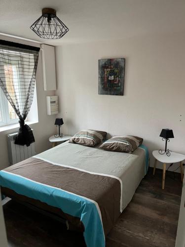 1 dormitorio con 1 cama y 2 mesas con lámparas en Jolie maison de campagne, Compostelle en Soleymieux
