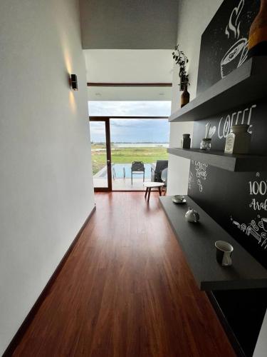 a living room with wooden floors and a view of the ocean at Blue Wild - Yala - Plastic Free & Sustainable in Tissamaharama