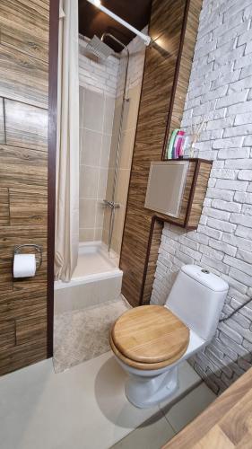 ein Badezimmer mit einem hölzernen WC und einer Badewanne in der Unterkunft Central Apartment in Sofia
