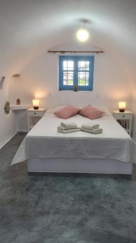 a bedroom with a bed with two towels on it at Fournos Aroniadika in Kythira