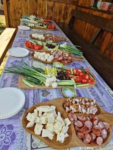 a table topped with different types of vegetables on plates at Glamping Livada cu lavanda in Podişor