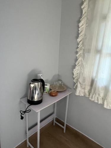 a small white table with a tea kettle on it at Pyramid Bangalow in Ban Laem Sai