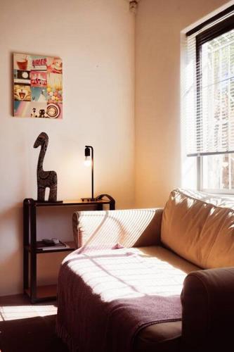 a living room with a couch and a dinosaur statue at Bains Kloof Cycling Retreat in Wellington