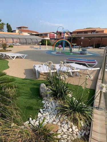 a park with a playground with tables and plants at MOBILHOME SOLEIA NEUF 2023 MAR ESTANG SIBLU VILLAGE Canet-en-Roussillon in Canet-en-Roussillon