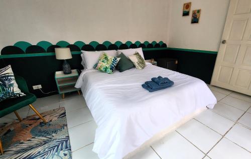 a bedroom with a white bed with a green headboard at Easy Life Koh Chang in Ko Chang