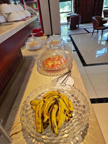 a table with a plate of bananas and a bowl of salsa at Golden Peacock Hotel Blantyre in Blantyre