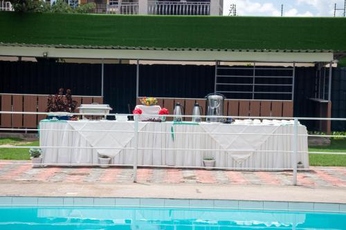a table is set up next to a swimming pool at Eldorado Rustic Hotel in Nakuru
