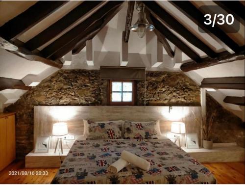 um quarto com uma cama grande numa parede de pedra em Casa Flores del Mediterráneo em Badalona