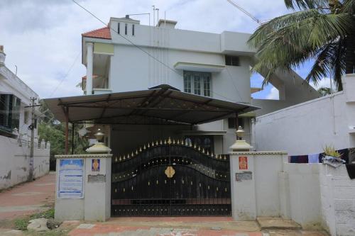 a building with a black gate with a large fence at Family friendly stay in Kanyakumari town in Kanyakumari