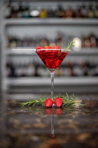a martini glass with strawberries on a table at Eldorado Rustic Hotel in Nakuru