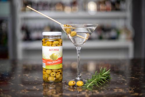 a bottle of olives and a martini glass on a table at Eldorado Rustic Hotel in Nakuru