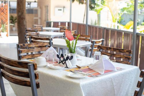 a table with a white table cloth on a patio at Eldorado Rustic Hotel in Nakuru
